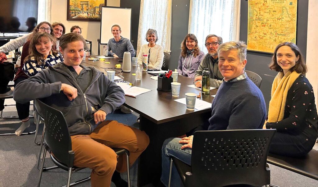 Group of smiling people sitting around a table