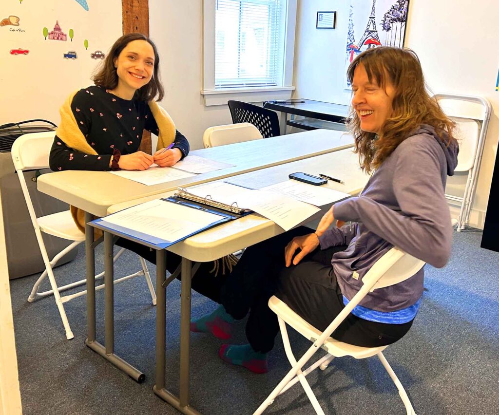 Two women sitting at a table, laughing